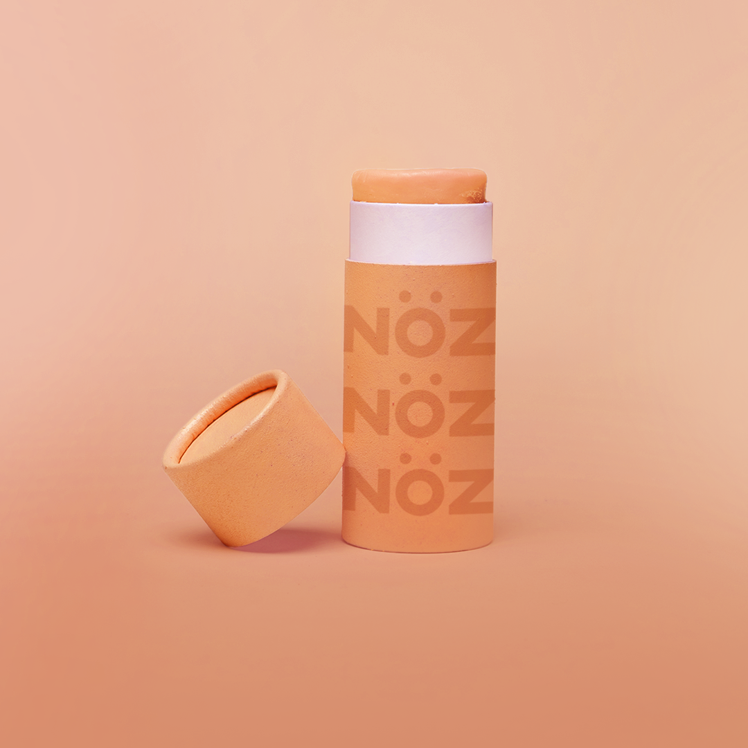 Opened light orange nose sunscreen container in modern orange biodegradable packaging